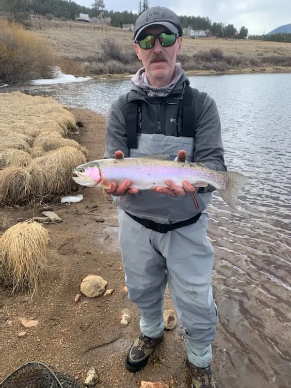 Member with a wild trout streamside